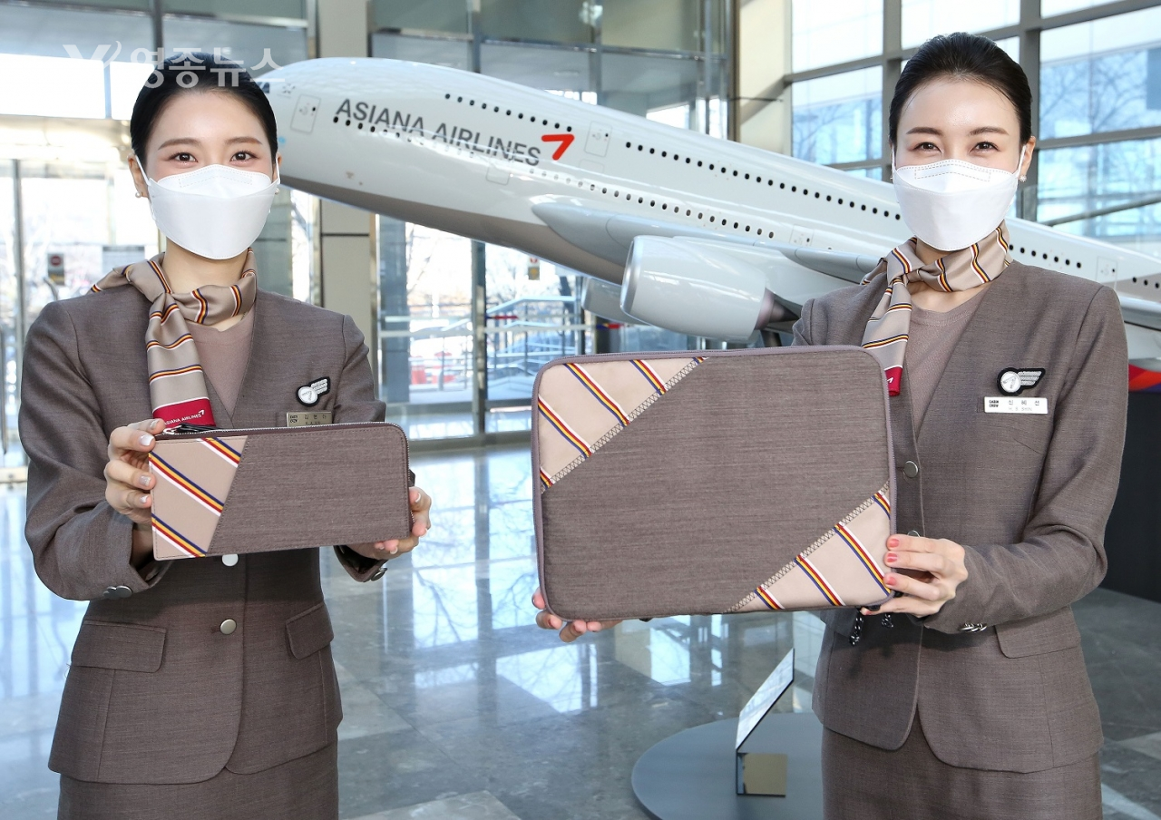 아시아나항공 승무원들이 회수한 유니폼을 이용해 제작한 업사이클링(Upcycling) 제품인 테블릿파우치를 소개하고 있다.